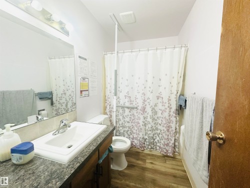 Bathroom featuring a white drop-in sink, chrome faucet, and a stone-look countertop - 221 Parkview Drive, Wetaskiwin, AB - Indoor Photo Showing Bathroom