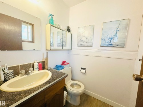 Bathroom featuring a wood-finish vanity with a dark countertop and integrated sink - 221 Parkview Drive, Wetaskiwin, AB - Indoor Photo Showing Bathroom