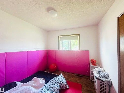 Room featuring wood-finish flooring, a single window with a roller shade, and a flush-mount ceiling light fixture - 221 Parkview Drive, Wetaskiwin, AB - Indoor
