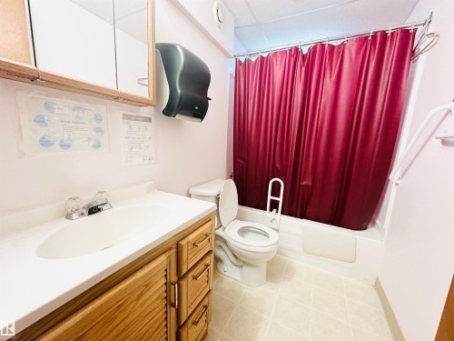 Bathroom featuring a white vanity with wood-finish cabinetry, a drop-in sink, and a mirrored medicine cabinet - 221 Parkview Drive, Wetaskiwin, AB - Indoor Photo Showing Bathroom