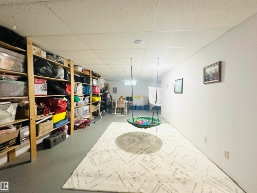 Spacious lower level with wood-finish shelving, drop ceiling, and light-toned flooring - 221 Parkview Drive, Wetaskiwin, AB - Indoor