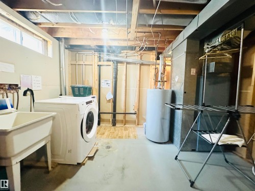 Dedicated laundry area with a utility sink, washer. - 221 Parkview Drive, Wetaskiwin, AB - Indoor Photo Showing Laundry Room