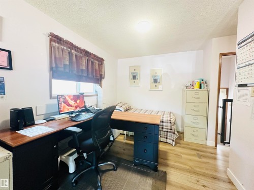Bedroom featuring wood-finish flooring, a window with horizontal blinds, and a flush-mount ceiling light - 221 Parkview Drive, Wetaskiwin, AB - Indoor Photo Showing Office