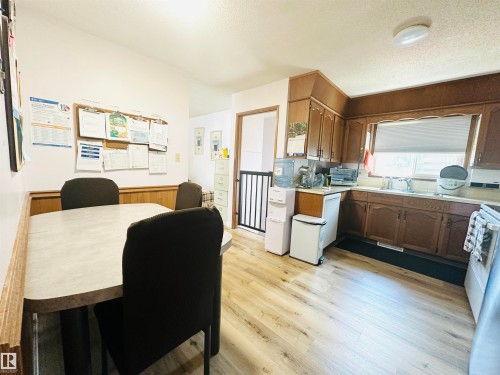 Kitchen featuring wood-finish flooring, wood cabinetry, and a window with blinds - 221 Parkview Drive, Wetaskiwin, AB - Indoor