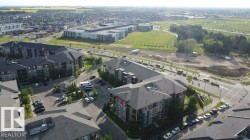 Aerial perspective showcasing multi-story residential buildings with dark shingle roofs and various exterior finishes including red and gray siding - 