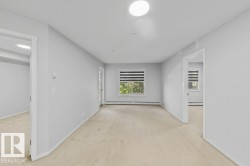 Carpeted interior space featuring light gray wall finishes and white trim - 
