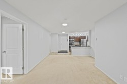 Open-concept living space featuring neutral carpeting and light-toned walls - 