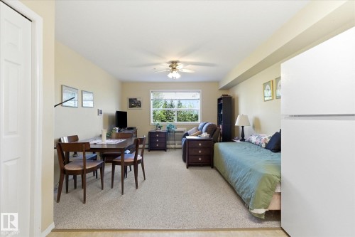 Open concept living area with light-colored walls and carpeted flooring - #230 8802 Southfort Dr, Fort Saskatchewan, AB - Indoor