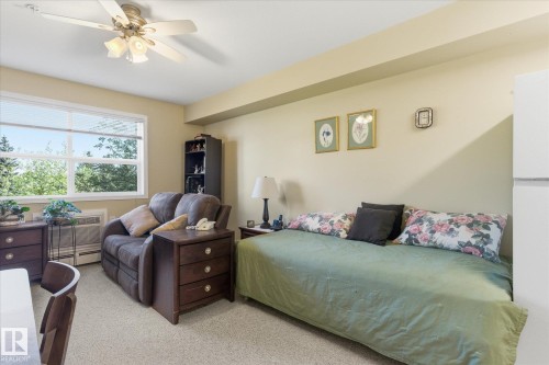 Bright interior space with a large window, light-toned walls, and a ceiling fan with integrated lighting - #230 8802 Southfort Dr, Fort Saskatchewan, AB - Indoor Photo Showing Bedroom