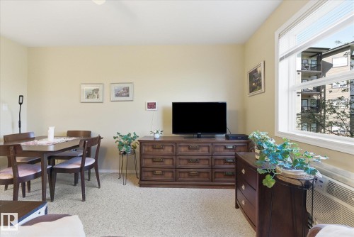 Open-concept living space with light-toned walls and neutral carpet - #230 8802 Southfort Dr, Fort Saskatchewan, AB - Indoor