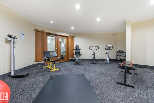 Fitness area featuring patterned carpet flooring, recessed lighting, and a neutral wall color - #230 8802 Southfort Dr, Fort Saskatchewan, AB - Indoor Photo Showing Gym Room