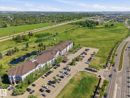 Multi-story complex featuring a brown shingle roof, white and gray exterior siding, and multiple balconies - #230 8802 Southfort Dr, Fort Saskatchewan, AB - Outdoor With View