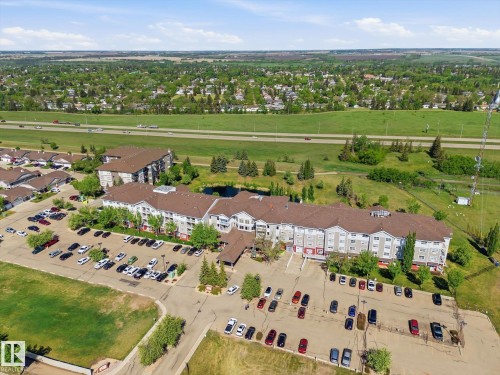 Expansive property featuring multiple multi-story buildings with light-colored siding and dark roofs - #230 8802 Southfort Dr, Fort Saskatchewan, AB - Outdoor With View