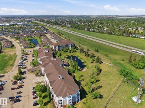 Aerial perspective showcasing multi-story residential buildings with brown shingled roofs - #230 8802 Southfort Dr, Fort Saskatchewan, AB - Outdoor With View