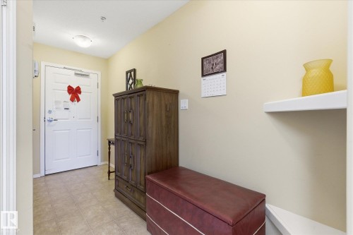 Entryway with light-toned wall paint and square floor tiles - #230 8802 Southfort Dr, Fort Saskatchewan, AB - Indoor Photo Showing Other Room