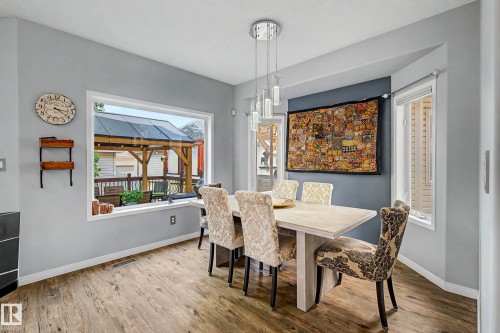 Dining area featuring wood-finish flooring and a large picture window - 9130 100A Avenue Nw, Edmonton, AB - Indoor Photo Showing Dining Room