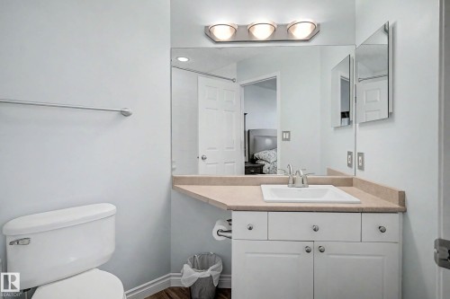 Bathroom featuring a single vanity with a laminate countertop, integrated sink, and chrome faucet - 9130 100A Avenue Nw, Edmonton, AB - Indoor Photo Showing Bathroom