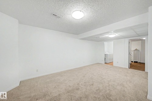 Expansive carpeted room with white walls, recessed lighting, and a white drop ceiling - 9130 100A Avenue Nw, Edmonton, AB - Indoor Photo Showing Other Room