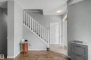 Foyer showcasing a wood-finish flooring, staircase with white railing, and a front entry door with an arched transom window - 9130 100A Avenue Nw, Edmonton, AB  - Indoor Photo Showing Other Room 