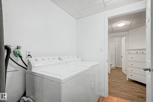 Laundry area featuring white walls, a drop ceiling, and a terracotta tile floor - 9130 100A Avenue Nw, Edmonton, AB - Indoor Photo Showing Laundry Room