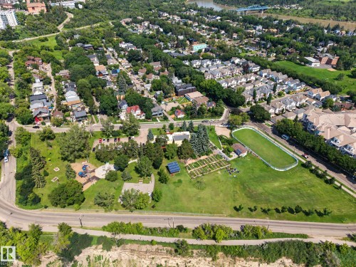 Aerial perspective showcasing a community park with a playground, an open green space, and cultivated garden plots - 9130 100A Avenue Nw, Edmonton, AB - Outdoor With View