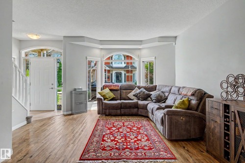 Wood-finish flooring throughout the main living area - 9130 100A Avenue Nw, Edmonton, AB - Indoor Photo Showing Living Room