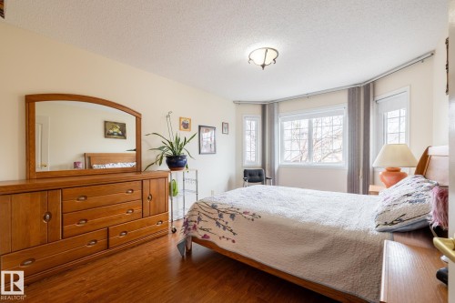 Bright interior space featuring a multi-pane bay window, wood-finish flooring, and a ceiling-mounted light fixture - #310 17151 94A Av Nw, Edmonton, AB - Indoor Photo Showing Bedroom