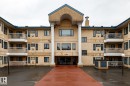 Multi-story building featuring a central entrance with a portico supported by white columns - #310 17151 94A Av Nw, Edmonton, AB  - Outdoor With Balcony With Facade 