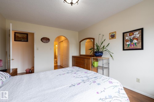 Room featuring wood-finish flooring, a ceiling-mounted light fixture, and an arched doorway - #310 17151 94A Av Nw, Edmonton, AB - Indoor Photo Showing Bedroom