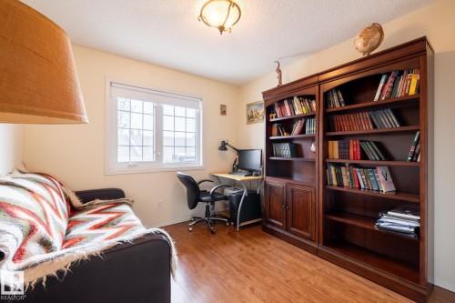 Room featuring wood-finish flooring, a double window with grid pattern, and a ceiling-mounted fixture - #310 17151 94A Av Nw, Edmonton, AB - Indoor Photo Showing Office