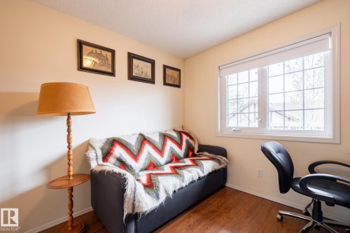 Bright room featuring a large window with gridded panes, light-toned walls, and wood-finish flooring - #310 17151 94A Av Nw, Edmonton, AB - Indoor Photo Showing Office
