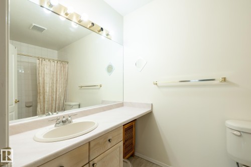 Vanity with an integrated oval sink and chrome faucet, set within a light-toned countertop - #310 17151 94A Av Nw, Edmonton, AB - Indoor Photo Showing Bathroom