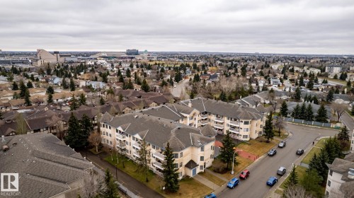 Expansive aerial perspective showcasing a residential neighborhood with multi-story apartment buildings featuring balconies and pitched roofs - #310 17151 94A Av Nw, Edmonton, AB - Outdoor With View