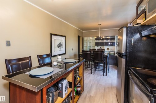 Wood-finish flooring throughout the dining area and kitchen - 13208 128 Avenue Nw, Edmonton, AB - Indoor
