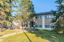 Two-story structure with stucco and horizontal siding accents, featuring a dark shingle roof and multiple windows - 13208 128 Avenue Nw, Edmonton, AB  - Outdoor 