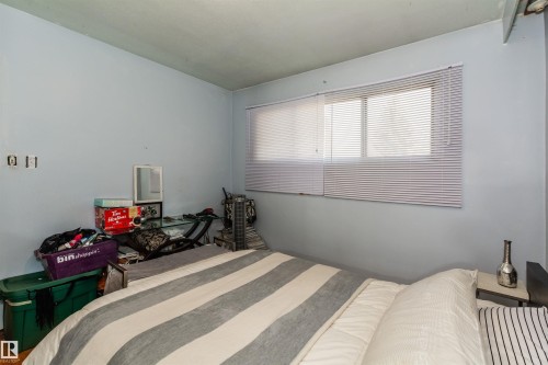 Room featuring light blue walls and a window with horizontal blinds - 13208 128 Avenue Nw, Edmonton, AB - Indoor Photo Showing Bedroom