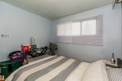 Room featuring light blue walls and a window with horizontal blinds - 