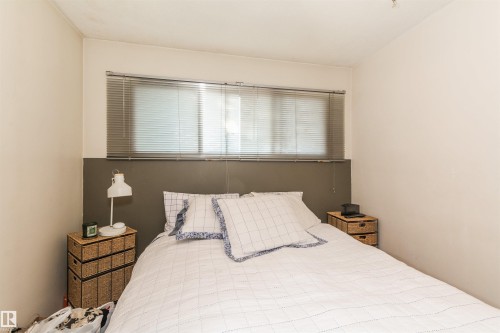 Bedroom featuring a dual-tone wall treatment, horizontal blinds, and a built-in headboard-style wall accent - 13208 128 Avenue Nw, Edmonton, AB - Indoor Photo Showing Bedroom