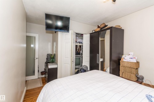 Wood-finish flooring with neutral wall tones - 13208 128 Avenue Nw, Edmonton, AB - Indoor Photo Showing Bedroom