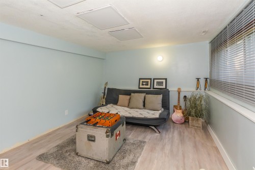 Light blue painted walls with a white baseboard and light wood-finish flooring - 13208 128 Avenue Nw, Edmonton, AB - Indoor