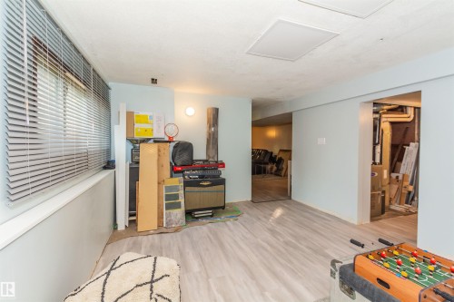 Finished room featuring wood-finish flooring, a window with horizontal blinds, and two recessed ceiling light fixtures - 13208 128 Avenue Nw, Edmonton, AB - Indoor Photo Showing Other Room