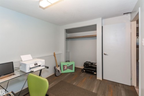Interior room featuring multi-tone wood-finish flooring and light-toned walls - 13208 128 Avenue Nw, Edmonton, AB - Indoor Photo Showing Office