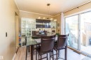 Dining area featuring light wood-finish flooring and a contemporary linear pendant light fixture - 13208 128 Avenue Nw, Edmonton, AB  - Indoor Photo Showing Dining Room 