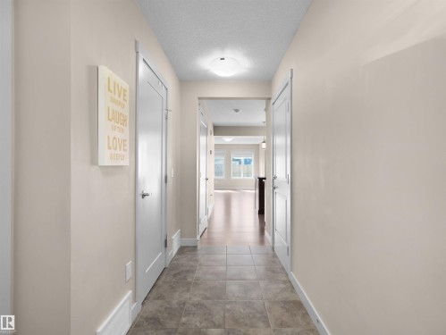Entryway featuring tile flooring, neutral wall tones, white trim, and white paneled doors - 4487 Annett Common Sw, Edmonton, AB - Indoor Photo Showing Other Room