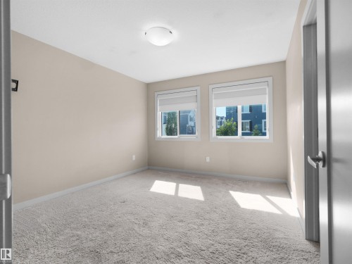 Neutral-toned room featuring light beige walls and light gray carpeting - 4487 Annett Common Sw, Edmonton, AB - Indoor Photo Showing Other Room