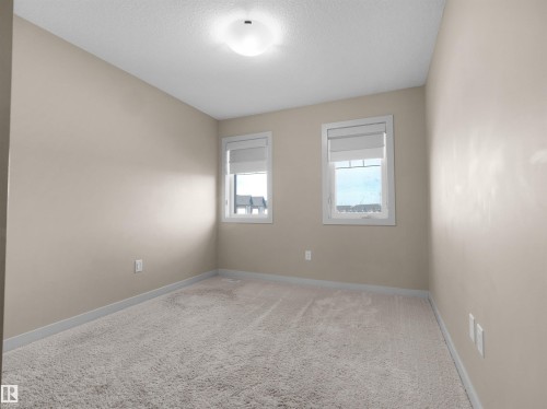 Neutral-toned room featuring a soft carpeted floor and two windows with blinds - 4487 Annett Common Sw, Edmonton, AB - Indoor Photo Showing Other Room