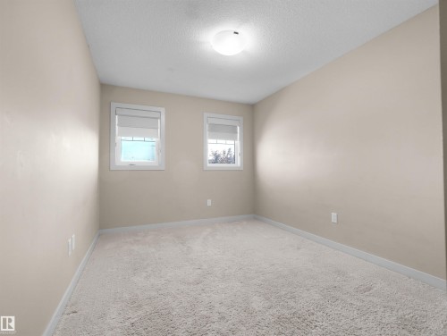 Neutral-toned room featuring light-colored walls and plush carpet flooring - 4487 Annett Common Sw, Edmonton, AB - Indoor Photo Showing Other Room