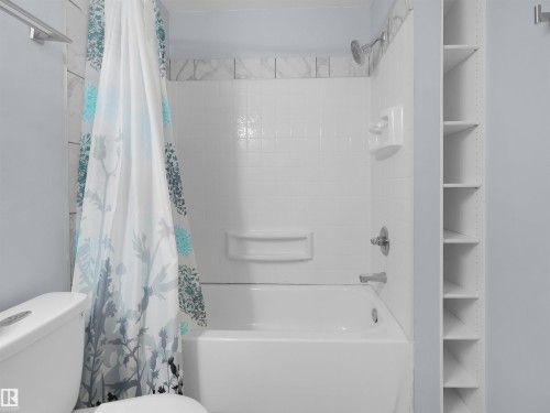 White tiled shower and bathtub combination with chrome fixtures - 4487 Annett Common Sw, Edmonton, AB - Indoor Photo Showing Bathroom
