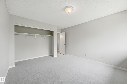 Bedroom featuring light grey carpeting, white baseboards, and a neutral wall color - #433 11217 103 Av Nw, Edmonton, AB - Indoor Photo Showing Other Room