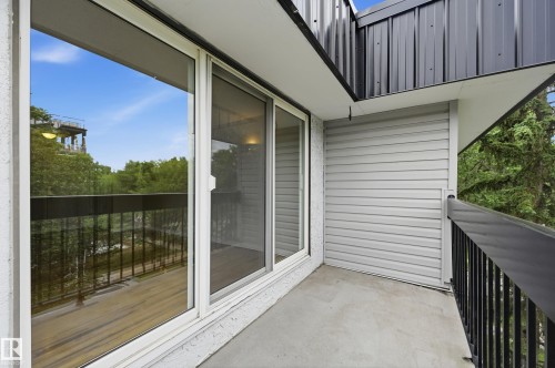 Private balcony featuring a concrete floor, black metal railing, and light gray siding - #433 11217 103 Av Nw, Edmonton, AB - Outdoor With Balcony With Exterior